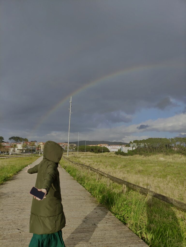 Persona en un paseo con un arcoíris de fondo