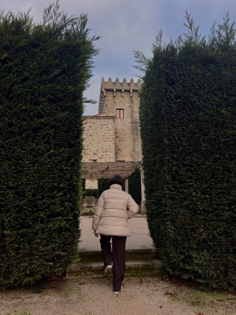 Persona de espaldas entre dos arbustos en un castillo